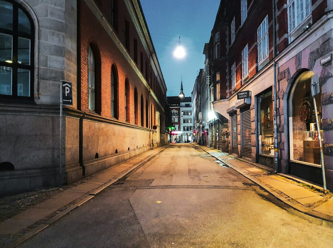 Empty cobblestone street at night under a full moon