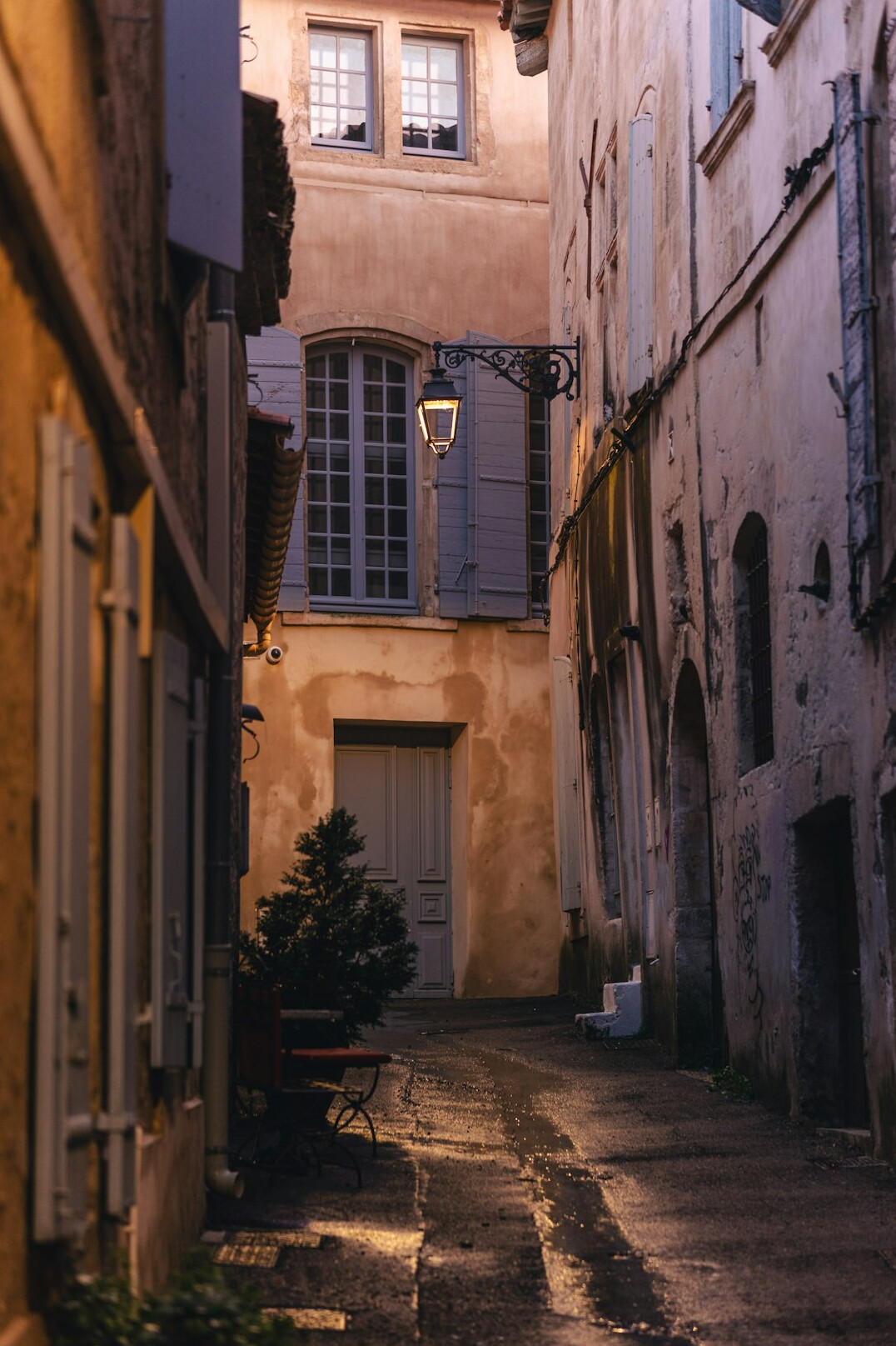 Narrow old town street at dusk with warm lights