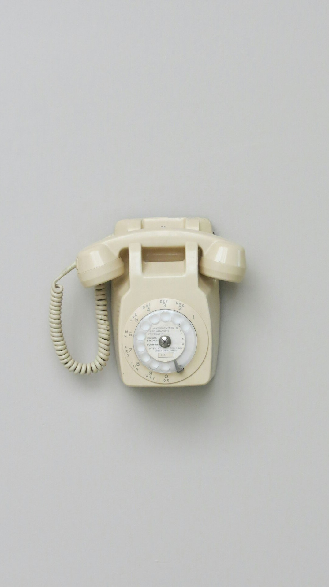 Old rotary telephone on a wooden desk